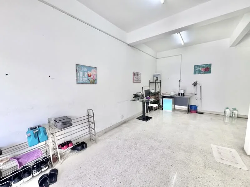 Room features: white painted walls, polished concrete flooring, ceiling lights, shelving unit, various shoes on rack, small table, plastic water bottles, decorative wall art; style: minimalist.