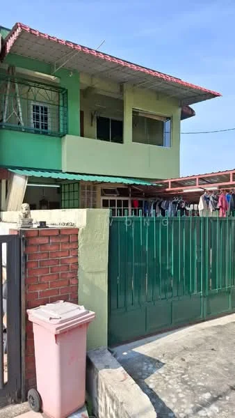 Exterior type: linked terrace house; features: green painted facade, red tiled roof, two-storey structure, metal gate, brick wall, clothes hanging on line, driveway with concrete pavement, front porch area; style: traditional.