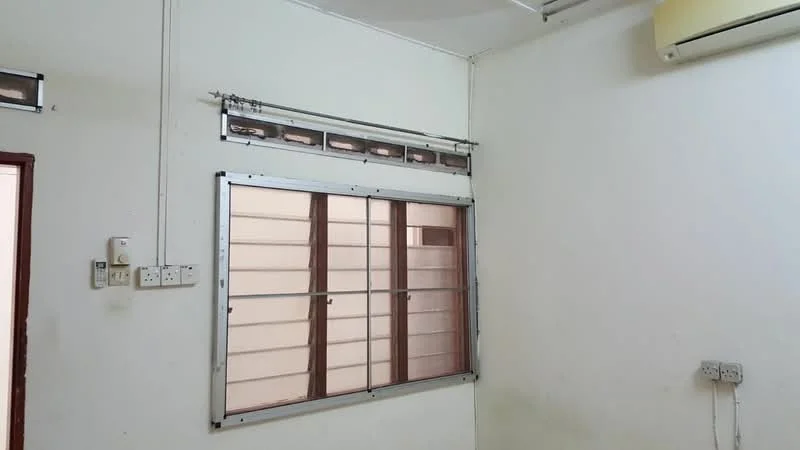 Room features: white painted walls, window with metal frame, air conditioning unit, exposed ceiling, light fixture, electrical outlets.