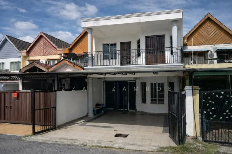 Exterior type: linked terrace house; features: two-storey building, white painted facade, balcony with black railing, gabled roof with wooden cladding, front porch with tiled flooring, double main entrance doors, visible air conditioning units, manicured driveway, fenced front yard, brick wall at entrance, sliding gate; style: modern.