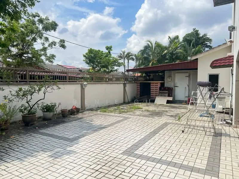 Exterior type: detached bungalow; features: paved driveway with interlocking pavers, manicured garden with potted plants, single-storey building, red tiled roof, fenced perimeter, outdoor storage area, open space for parking, surrounded by greenery; style: modern.