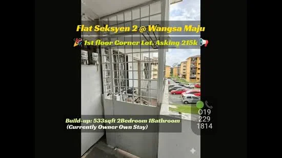 Exterior type: low-rise apartment block; features: first floor unit, corner lot, grilled security gate, concrete balcony, surrounding residential buildings, open view of the street, parking area visible, manicured landscaping; style: modern.