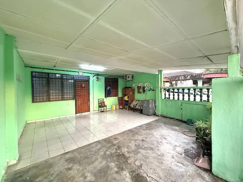 Exterior features: green painted walls, tiled flooring, exposed concrete flooring, window with metal grille, wall-mounted air conditioning unit, door with wooden frame, decorative railing, potted plants, outdoor seating area.