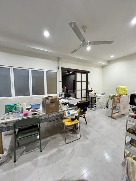 Room features: white painted walls, recessed downlights, 5-blade ceiling fan, glossy tile flooring, large windows with frosted glass, wooden sliding door, multiple tables, various storage boxes, folding chairs, laundry drying rack.