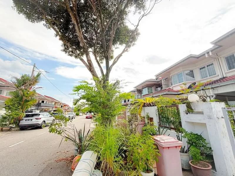 Exterior type: linked terrace house; features: manicured lawn, mature trees, tropical landscaping, stone-paved walkway, white painted facade, red tiled roof, driveway with interlocking pavers, front garden with plants, visible street view, surrounded by residential houses; style: modern.