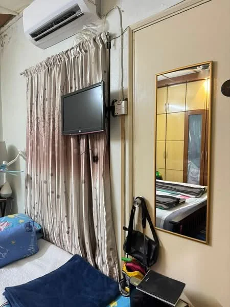 Room features: wall-mounted TV, curtains with floral pattern, wall-mounted air conditioning unit, full-length mirror, built-in wardrobe with sliding doors, bed with bedding, bedside lamp, decorative items on the bedside table.