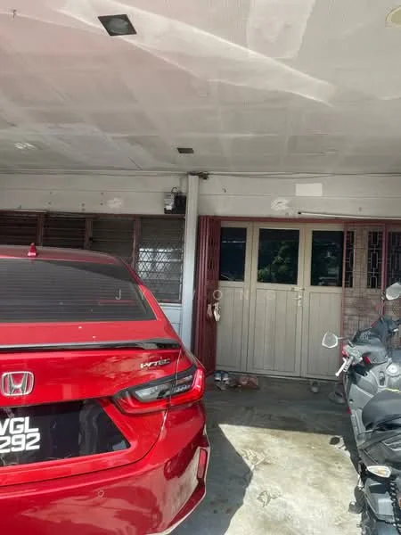 Exterior type: car porch; features: covered car porch, concrete flooring, red painted walls, metal grilles on windows, double doors, visible motorcycle, red car, light fixtures on ceiling.