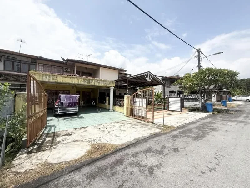 Exterior type: linked terrace house; features: open-air car porch, paved driveway, single-storey, manicured lawn, front gate with metal bars, exposed brick facade, surrounded by greenery, adjacent to quiet residential street; style: modern.