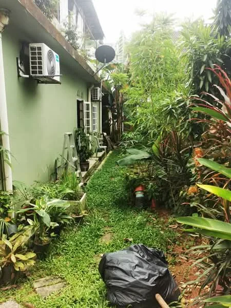 Exterior features: green painted facade, manicured lawn, tropical landscaping, mature trees, air conditioning unit mounted on wall, pathway leading to entrance, garden with various plants, garbage bag on ground.
