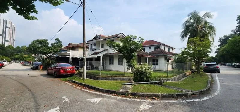 Exterior type: detached bungalow; features: two-storey building, red tiled roof, white painted facade, surrounded by greenery, fenced yard, paved driveway, mature trees, front porch, corner lot, adjacent to road, parking space for multiple cars; style: traditional.