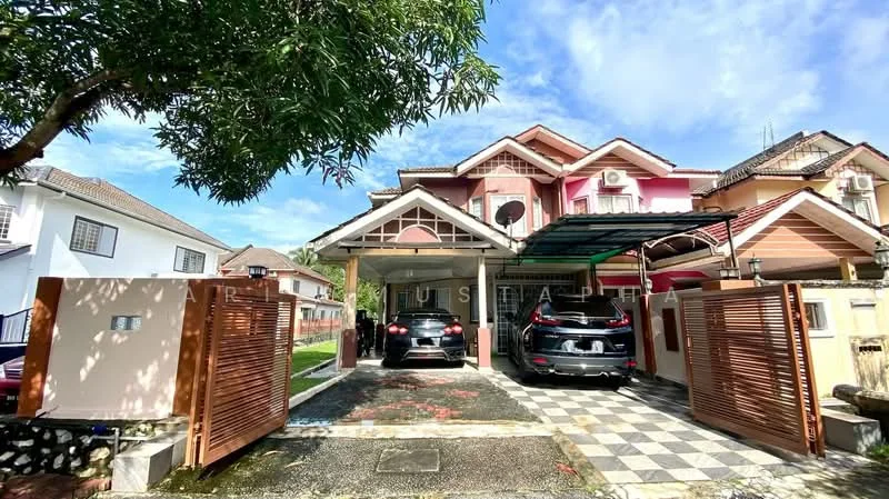Exterior type: linked terrace house; features: two-storey building, pink and cream painted facade, covered car porch, two parked cars, manicured lawn, paved driveway, wooden gate, air conditioning units visible, gabled roof, balcony on upper floor; style: modern.
