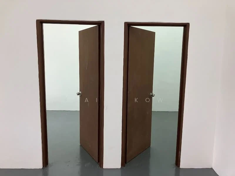 Room features: two wooden doors, grey concrete flooring, white painted walls, no visible windows, minimal decor; style: minimalist.