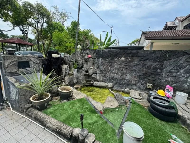 Exterior type: landscape garden; features: rock garden with water feature, artificial grass, potted plants, stone pathway, decorative stones, tire planter, outdoor lighting fixture, fenced area, tropical landscaping, garden wall with stone cladding; style: tropical-modern.