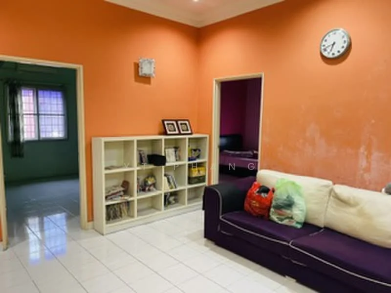 Living features: orange painted walls, white tiled flooring, 3-seater fabric sofa in purple, built-in shelving unit with books, wall clock, recessed lighting, window with sheer curtains. Room features: green painted walls, white tiled flooring, window with sheer curtains.