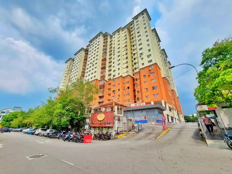 Exterior type: high-rise condominium; features: multi-storey building, orange and cream painted facade, balconies on upper floors, surrounded by greenery, parking area visible, entrance with signage, driveway leading to entrance, street view with parked vehicles; style: modern.