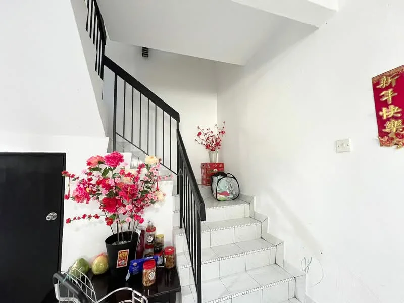 Room features: spiral staircase with black railing, white painted walls, white tiled flooring, decorative flower arrangements, wall-mounted decorations, small round table, various decorative items on the table, fruit display on the table; style: minimalist.