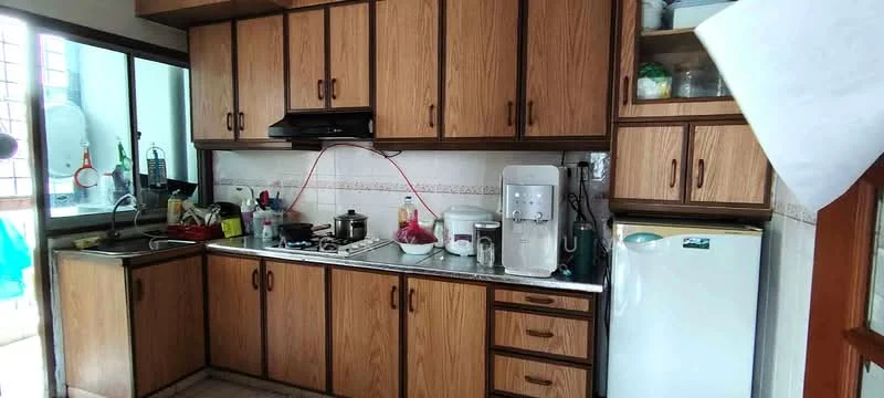 Kitchen features: wood cabinetry with brown finish, black countertop, stainless-steel sink, chrome pull-down faucet, built-in gas stove, exhaust hood, microwave, white refrigerator, ceramic tile flooring, wall-mounted storage shelves, window with sheer curtains, decorative wall tiles, kitchen appliances including kettle and rice cooker; style: traditional.