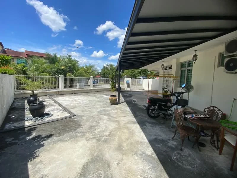 Exterior type: detached bungalow; features: covered porch with metal roof, concrete flooring, decorative stone feature with water feature, potted plants, outdoor seating area with table and chairs, motorcycle parked, air conditioning units mounted on wall, fenced perimeter, landscaped garden area, clear blue sky; style: modern.