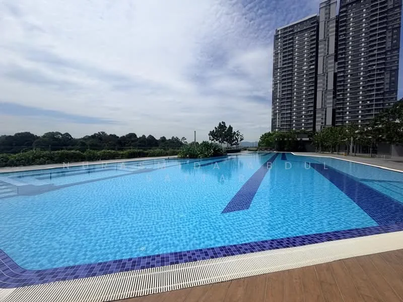 Exterior type: swimming pool deck; features: infinity pool, blue mosaic tile pool surface, wooden deck surrounding pool, landscaped greenery in background, high-rise condominium in background, clear sky, poolside loungers, pool edge with white coping; style: modern.