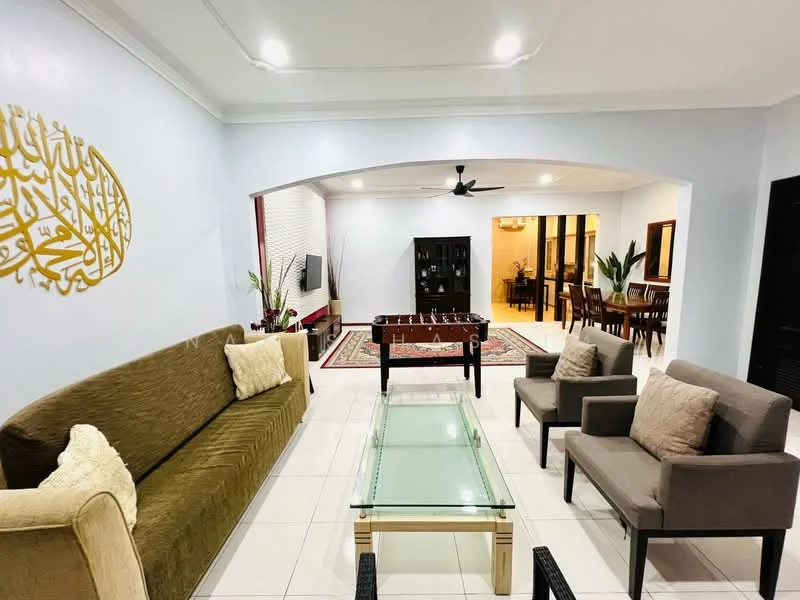 Living features: green fabric sofa, glass coffee table, 2 grey armchairs, decorative wall with Arabic calligraphy, recessed ceiling lights, ceiling fan, tile flooring, area rug with geometric pattern, wall-mounted TV, plant decoration; style: modern. Dining features: dining table with multiple chairs, wooden cabinet, decorative plants, tile flooring; style: modern.