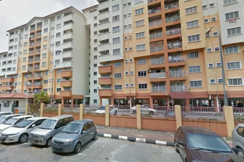 Exterior type: mid-rise condominium; features: cream painted facade, orange accent panels, balconies with metal railings, multiple windows, ground-level parking area, surrounding fence, landscaped entrance, visible parking spaces; style: modern.