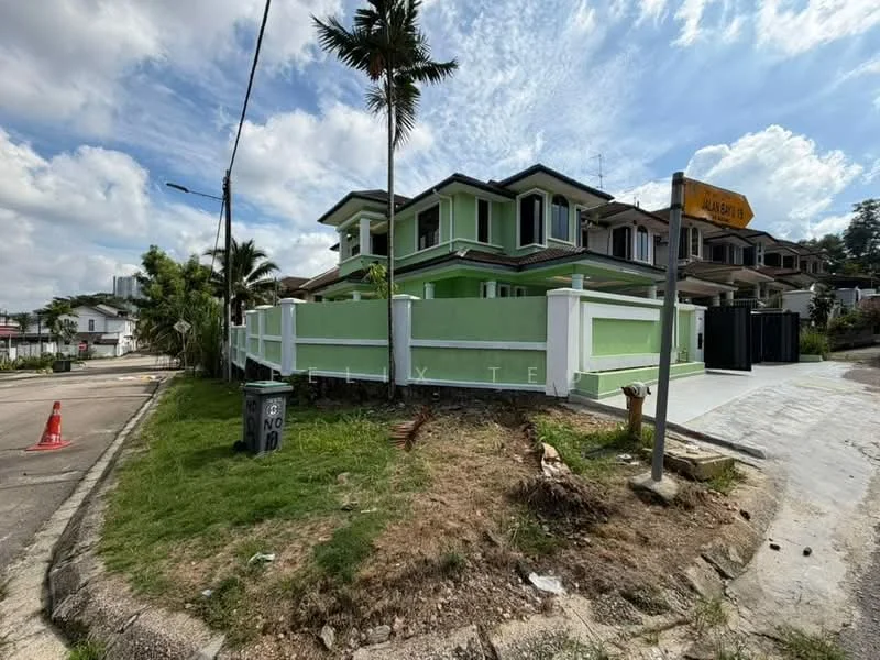 Exterior type: detached bungalow; features: green painted facade, two-storey structure, flat roof, surrounded by white fence, manicured lawn, palm trees, corner lot, driveway, street signage, adjacent to residential area; style: modern.