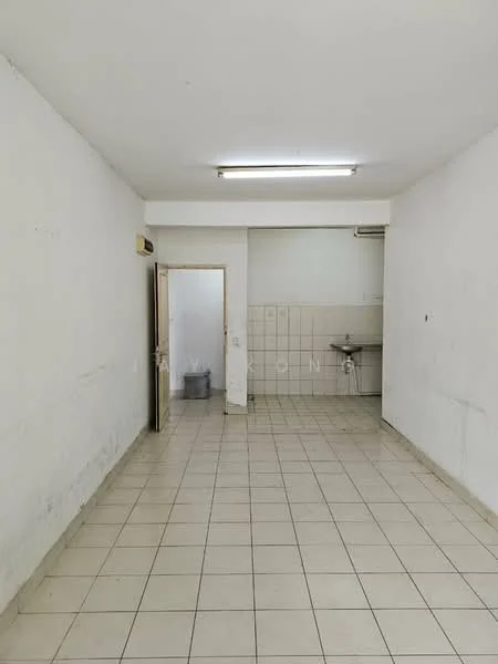 Room features: white painted walls, tile flooring, fluorescent ceiling lights, wall-mounted air conditioning unit, sink with wall-mounted faucet, empty space, doorway leading to another room, light switch.