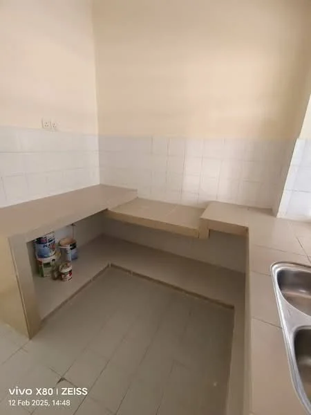 Kitchen features: L-shaped countertop, light-colored laminate countertop, white tiled backsplash, cream painted walls, tile flooring, double-bowl stainless-steel sink, under-counter storage space, open shelving, paint cans visible in storage area; style: modern.