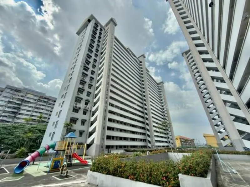 Exterior type: high-rise condominium; features: white painted facade, vertical fins, playground with slide and climbing structure, manicured landscaping, surrounding greenery, multiple storeys, balconies on each floor, open-air parking area; style: modern.