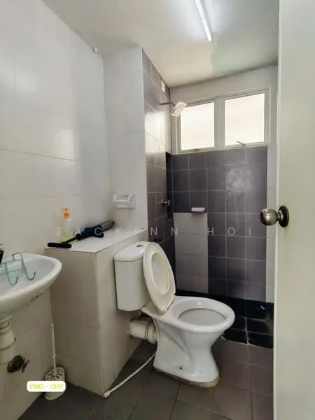 Bathroom features: white tiled walls, grey tiled walls, black tiled flooring, single-sink vanity, toilet, shower area with glass partition, window for natural light, overhead fluorescent lighting.
