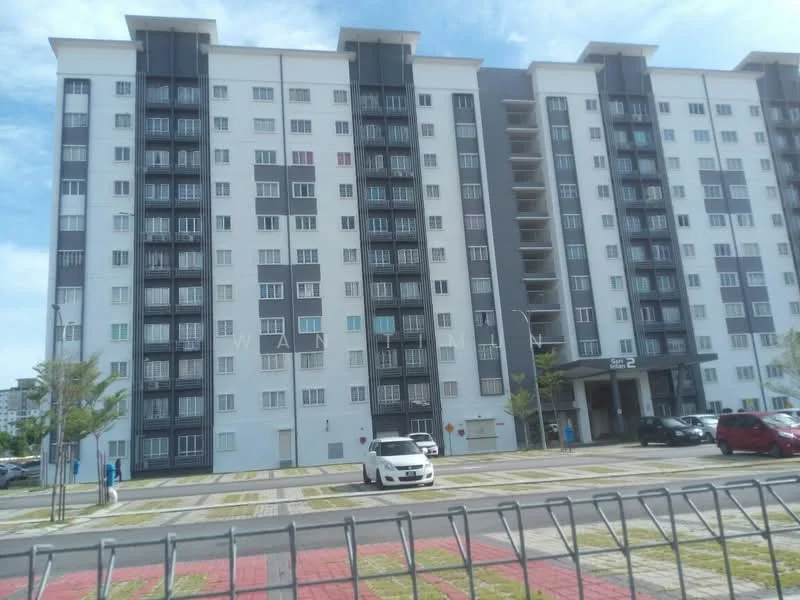 Exterior type: mid-rise condominium; features: grey and white painted facade, balconies on upper floors, multiple windows with metal grilles, entrance with awning, landscaped area in front, paved walkway, parking spaces visible, surrounded by greenery; style: modern.