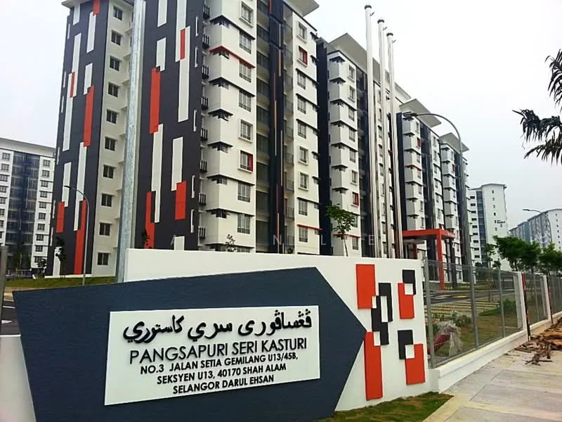 Exterior type: mid-rise condominium; features: white painted facade, red accent panels, grey accent panels, multiple storeys, balconies on upper floors, landscaped entrance, signage at entrance, surrounding greenery, modern architectural design; style: modern.