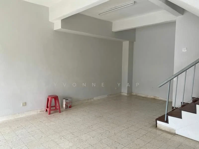 Room features: grey painted walls, white ceiling, tile flooring, staircase with wooden steps, handrail, single red stool, empty space.