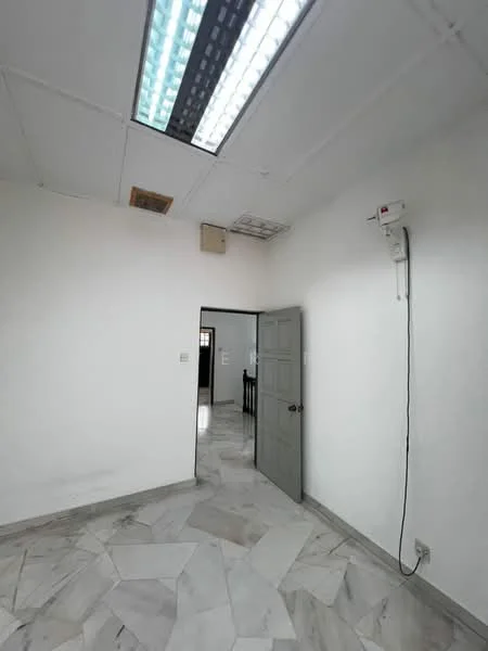 Room features: white painted walls, marble flooring, ceiling with fluorescent lights, door with grey finish, door frame, visible electrical outlet, ventilation grill, window opening, neutral color scheme; style: modern.