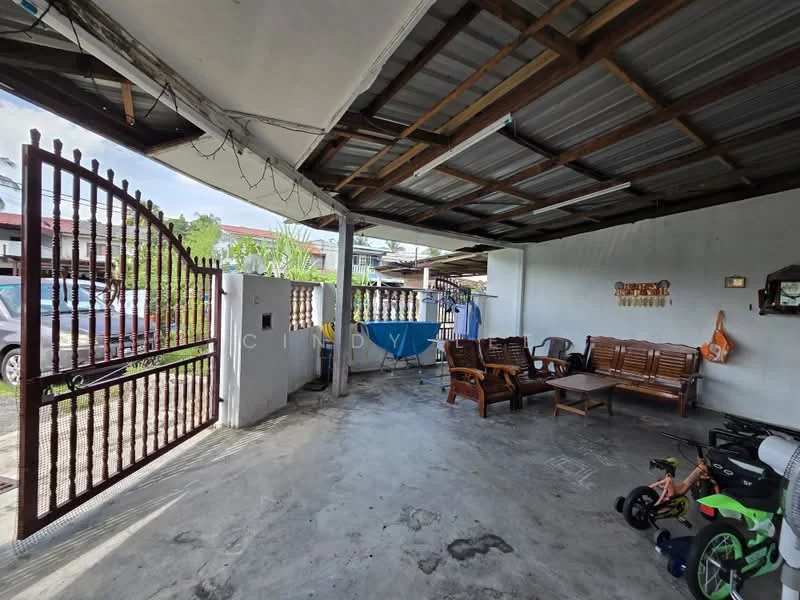 Exterior type: linked terrace house; features: metal gate, concrete flooring, open car porch, wooden seating, exposed beams on ceiling, partially covered roof, surrounded by greenery, wall with decorative elements; style: modern.