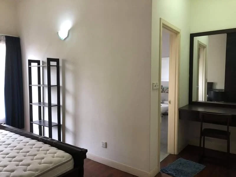 Bedroom features: wooden flooring, white painted walls, single bed frame, mattress, built-in wardrobe, desk with mirror, chair, wall-mounted light fixture, curtains, window, blue bath mat.