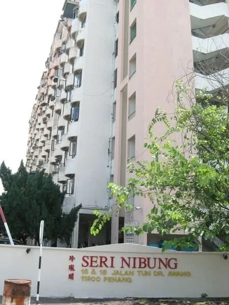 Exterior type: mid-rise condominium; features: cream painted facade, balconies with sliding glass doors, landscaped garden with trees, entrance gate with signage, multiple storeys, surrounded by greenery; style: modern.