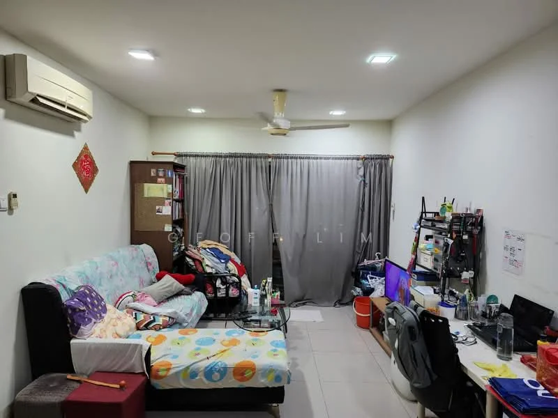 Living features: sofa with floral upholstery, single bed with colorful bedding, wall-mounted split AC, 5-blade ceiling fan, grey curtains, tile flooring, wall-mounted desk, computer monitor, plastic storage bins, decorative wall hanging, bookshelf with books, cluttered workspace.