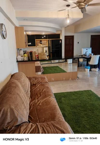 Living features: 3-seater fabric sofa in brown, coffee table, area rug in green, wall-mounted TV, open shelving unit, kitchen island with bar stools, pendant light, recessed downlights, floor-to-ceiling windows, wooden cabinetry, black appliances, ceramic tile flooring, white painted walls, ceiling fan; style: modern. Kitchen features: kitchen island, black cabinetry, stainless-steel sink, chrome pull-down faucet, built-in oven, freestanding range oven, microwave, refrigerator, ceramic tile backsplash, granite countertop; style: modern.