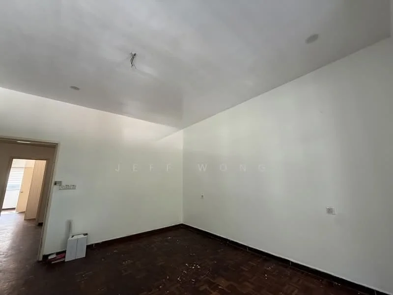Room features: white painted walls, plain ceiling, dark wooden flooring, no visible furniture, single light fixture, doorway leading to another room, no visible windows; style: minimalist.