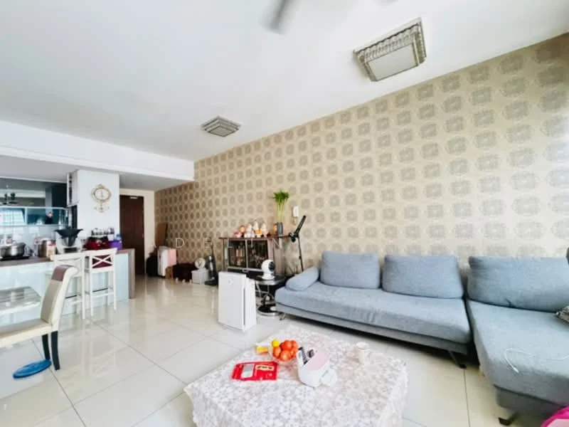 Living features: grey fabric sofa, white coffee table, decorative tablecloth, wall-mounted TV, glass display cabinet, cream wallpaper with pattern, white tiled flooring, ceiling fan, potted plant, fruit bowl with oranges, dining area visible in background, open layout to kitchen; style: contemporary.