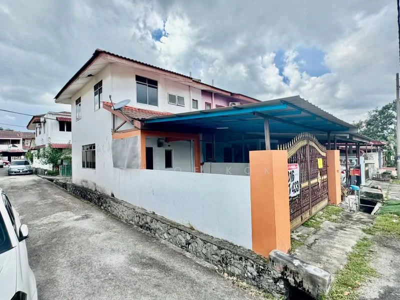 Exterior type: semi-detached house; features: white painted facade, orange accent wall, flat roof, two-storey structure, manicured lawn, driveway with interlocking pavers, gate at entrance, surrounded by greenery; style: modern.