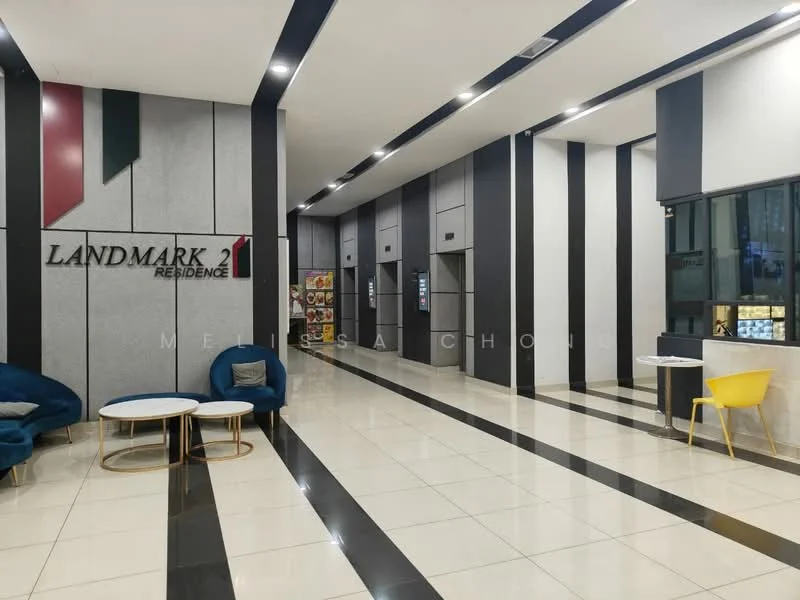 Lobby features: grey and black accent walls, white painted walls, polished tile flooring, recessed LED downlights, elevators visible, seating area with blue armchairs, round coffee table, yellow chair, decorative wall signage, large window with view to exterior; style: modern.