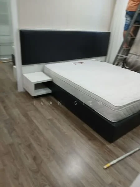 Bedroom features: queen-size bed frame with storage, mattress without bedding, black upholstered headboard, white bedside table, wooden flooring, wall-mounted light fixture, neutral wall color, ladder in background; style: modern.