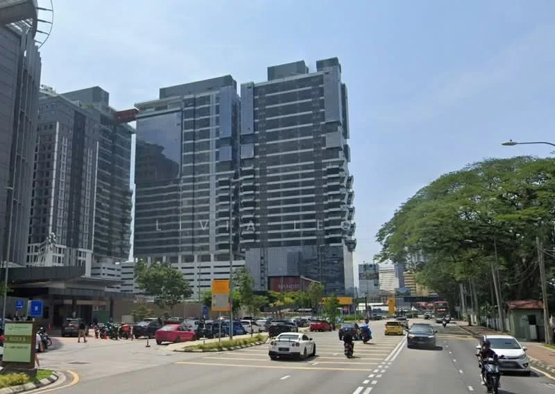 Exterior type: high-rise condominium; features: glass curtain wall, projecting balconies, multiple storeys, surrounded by mature greenery, urban context with main road, visible parking area; style: modern.
