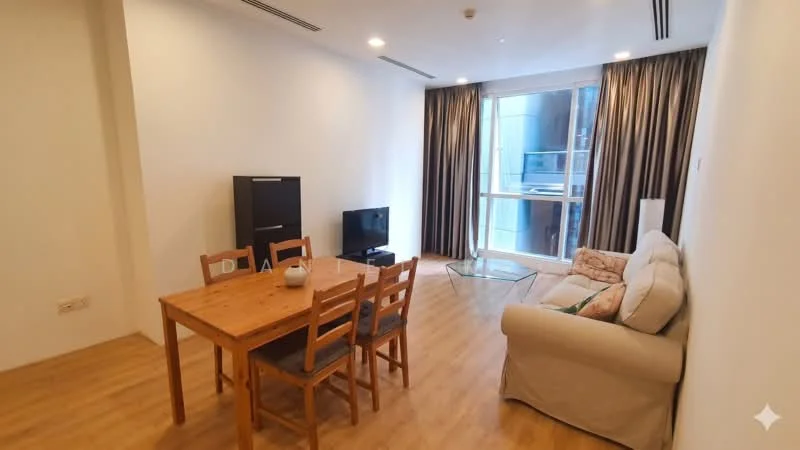 Living features: light wood laminate flooring, white painted walls, floor-to-ceiling windows, sheer curtains, sofa in light beige, wooden dining table with four chairs, TV console, wall-mounted TV, glass coffee table, decorative cushions; style: modern; view: city.