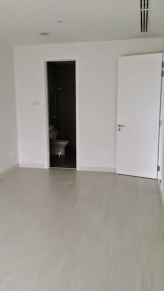 Room features: white painted walls, light wood flooring, door leading to bathroom, door leading to another room, recessed ceiling lights, air conditioning vent; style: modern.