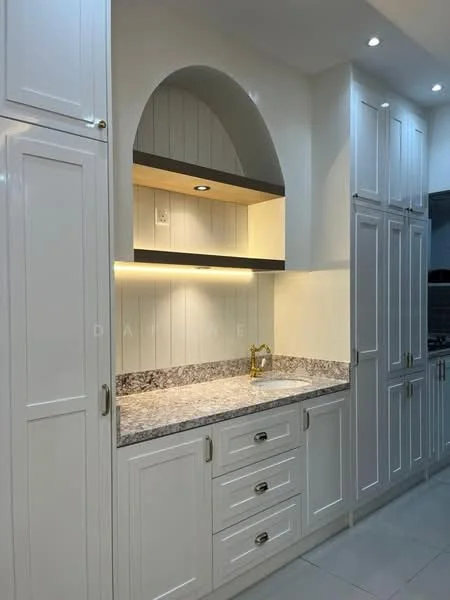 Kitchen features: white shaker cabinets, granite countertop, built-in shelving, under-cabinet lighting, gold faucet, ceramic tile flooring, recessed downlights, arched feature above countertop; style: modern.