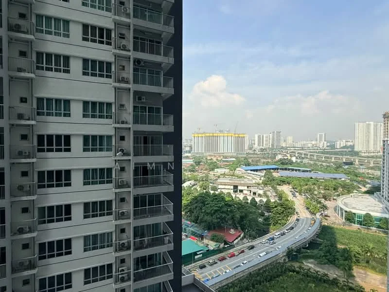 Exterior type: high-rise condominium; features: glass curtain wall, balconies with glass railings, multiple air conditioning units visible, surrounding urban landscape, city skyline in background, roadway visible in foreground, greenery at base of building, construction site in distance; style: modern.