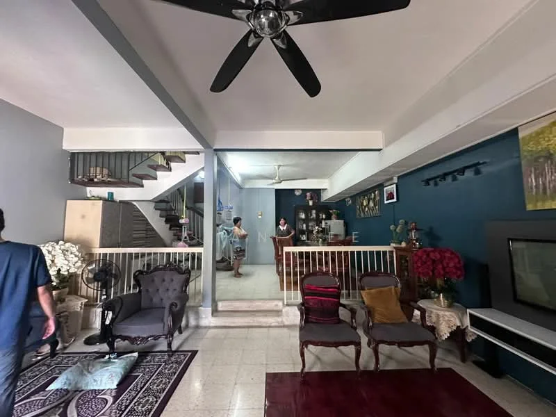 Living features: 5-blade ceiling fan, sofa with upholstery in dark fabric, armchair with wooden frame, coffee table, area rug with geometric pattern, wall-mounted TV, decorative wall art, potted plants, open staircase, light grey painted walls, tile flooring; style: contemporary. Room features: wooden railing, staircase with metal railing, decorative items on shelves, seating area with dining table.
